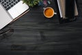 Modern dark wood office desk table with laptop, smartphone and other supplies with cup of coffee. Blank notebook page for input Royalty Free Stock Photo