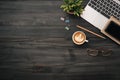 Modern dark wood office desk table with laptop, smartphone and other supplies with cup of coffee. copy space for input the text in