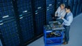 In the Modern Data Center: Engineer and IT Specialist Work with Server Racks, on a Pushcart Equipm Royalty Free Stock Photo