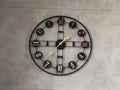 Modern decorative wall clock with roman numerals on a gray wall Royalty Free Stock Photo