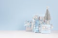 Modern delicate christmas background with copy space - silver tree and various festive gift boxes with sparkles ribbons.