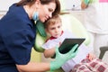 Modern dentist use wireless tablet with kid patient