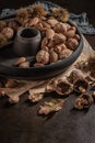 Modern design black ceramic bowl with walnuts, hazelnuts, almonds, chestnut hedgehogs on dark countertop and background. Autumn Royalty Free Stock Photo