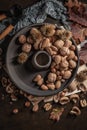 Modern design black ceramic bowl with walnuts, hazelnuts, almonds, chestnut hedgehogs on dark countertop and background. Autumn Royalty Free Stock Photo