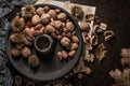 Modern design black ceramic bowl with walnuts, hazelnuts, almonds, chestnut hedgehogs on dark countertop and background. Autumn Royalty Free Stock Photo