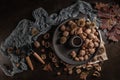 Modern design black ceramic bowl with walnuts, hazelnuts, almonds, chestnut hedgehogs on dark countertop and background. Autumn Royalty Free Stock Photo