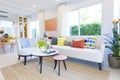 Modern design of living room with yellow,blue and orange pillow on sofa.