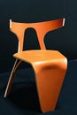 Modern design protoype of orange wooden chair with steel rear legs and support, made by students