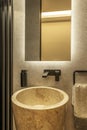 Modern design toilet with brown marble sink, highly textured wall