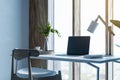 Modern designer desktop with mock up laptop, various objects and window with city view in the background. Royalty Free Stock Photo