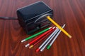 Desk electric pencil sharpener and pencils on the wooden table Royalty Free Stock Photo