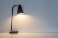 The modern desk lamp illuminate on the wall background. Royalty Free Stock Photo