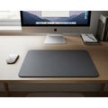Modern desk setup featuring an Apple iMac with a visible desktop screen displaying Royalty Free Stock Photo