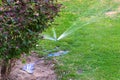 The modern device of the irrigation garden. Automatic sprinkler system of lawn watering on a background of green grass, close-up. Royalty Free Stock Photo