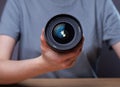 Modern digital camera lens 35 mm in hands of female photographer, close up Royalty Free Stock Photo