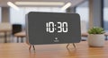 Modern digital clock displaying 10 30 rests on a wooden table Royalty Free Stock Photo