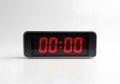 Modern digital clock displaying zero time with bright red illuminated numerals on a clean white surface Royalty Free Stock Photo