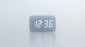 Modern digital clock glowing 12:36 on a clean, minimalist surface Royalty Free Stock Photo