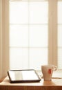 Modern Digital Devices on Wooden Table, Blurred windows background, Digital Tablet, Tea and Newspaper