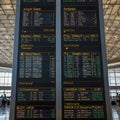 Modern Digital Flight Information Board in Busy Airport Terminal