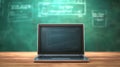 Modern Digital Learning Concept with Laptop on Wooden Desk in Front of Green Chalkboard Background Royalty Free Stock Photo