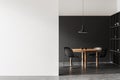 Modern dining room interior with a wooden table, black chairs, and a pendant lamp. Black and white background, minimalist concept Royalty Free Stock Photo