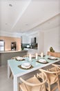 Modern dining room setup with candles flashing in front of the kitchen