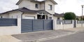 Modern door gate of white two storey house driveway entrance gates home access garage in suburb