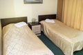 Modern double room with two single beds, bedside table, towels and table lamp, cozy inexpensive room for travelers, good service