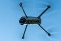 A modern drone against a clear blue sky. The quadcopter hovered motionless in the sky. The use of aircraft for reconnaissance and Royalty Free Stock Photo