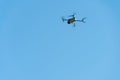 A modern drone against a clear blue sky. The quadcopter hovered motionless in the sky. The use of aircraft for reconnaissance and Royalty Free Stock Photo