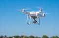 The modern drone, quadrocopter is in the air against the background of the sky and grass Royalty Free Stock Photo