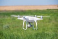 The modern drone, quadrocopter is in the air against the background of the sky and grass Royalty Free Stock Photo