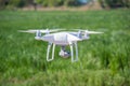 The modern drone, quadrocopter is in the air against the background of the sky and grass Royalty Free Stock Photo