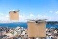Modern drones with carton boxes flying above city on sunny day. Delivery service
