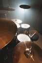 Modern drum set prepared for playing in a dark rehearsal room on stage with a bright spotlight. The concept of Royalty Free Stock Photo