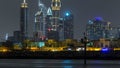 Modern Dubai city skyline timelapse at night with illuminated skyscrapers over water surface Royalty Free Stock Photo