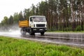 A modern dump truck for transporting bulk cargo drives on the highway in rainy weather. Safe driving in bad weather Royalty Free Stock Photo