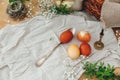 Modern Easter eggs  on rustic table with spring flowers, candle,  basket. Stylish red and yellow Easter eggs painted in natural Royalty Free Stock Photo