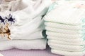 Modern eco stacks of cloth diapers and disposable diapers, pampers, selective focus close-up on bright background