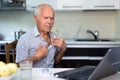 Modern elderly man sit at home having online consultation with doctor on computer, sick senior male talk on video call consulting Royalty Free Stock Photo