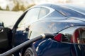 Modern electric car plugged to charging station. Royalty Free Stock Photo