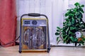 Modern electric fan heater on the floor in the kitchen next to a cold radiator.. Royalty Free Stock Photo