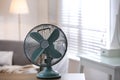 Modern electric fan on wooden table indoors. Space for text Royalty Free Stock Photo