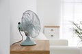 Modern electric fan on wooden table indoors. Space for text Royalty Free Stock Photo