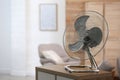 Modern electric fan on wooden table indoors. Space for text Royalty Free Stock Photo