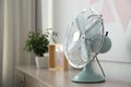 Modern electric fan on wooden table, space for text. Summer heat Royalty Free Stock Photo