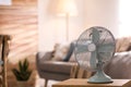 Modern electric fan on wooden table in living room. Space for text Royalty Free Stock Photo