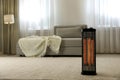 Modern electric halogen heater on floor in living room interior Royalty Free Stock Photo