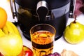 Modern electric juicer, various fruit and glass of freshly made juice, healthy lifestyle concept Royalty Free Stock Photo